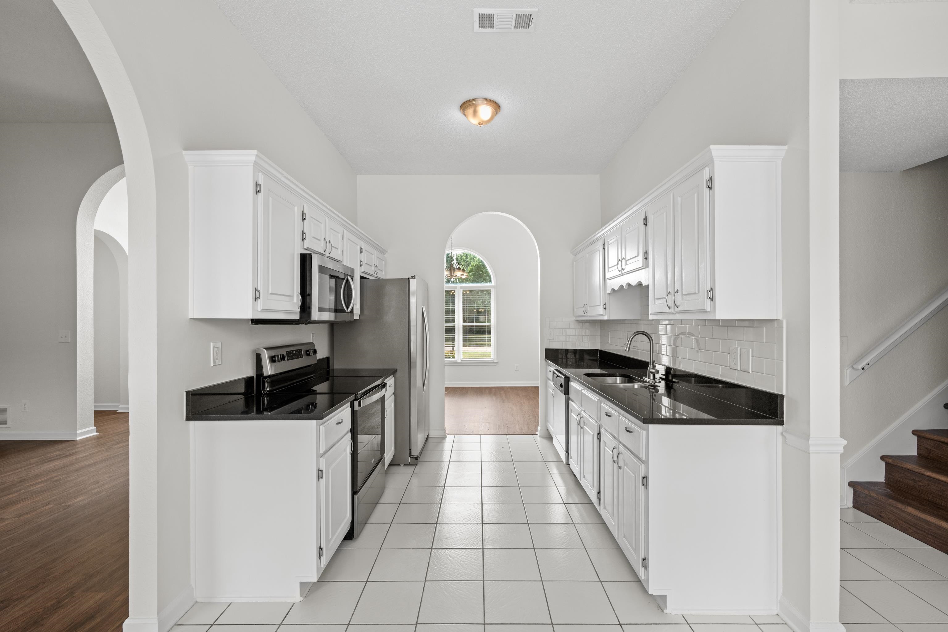 8016 Cale Falls Lane Bartlett, TN 38002 - Photo 13 of 37 a kitchen with stainless steel appliances granite countertop a stove and a refrigerator