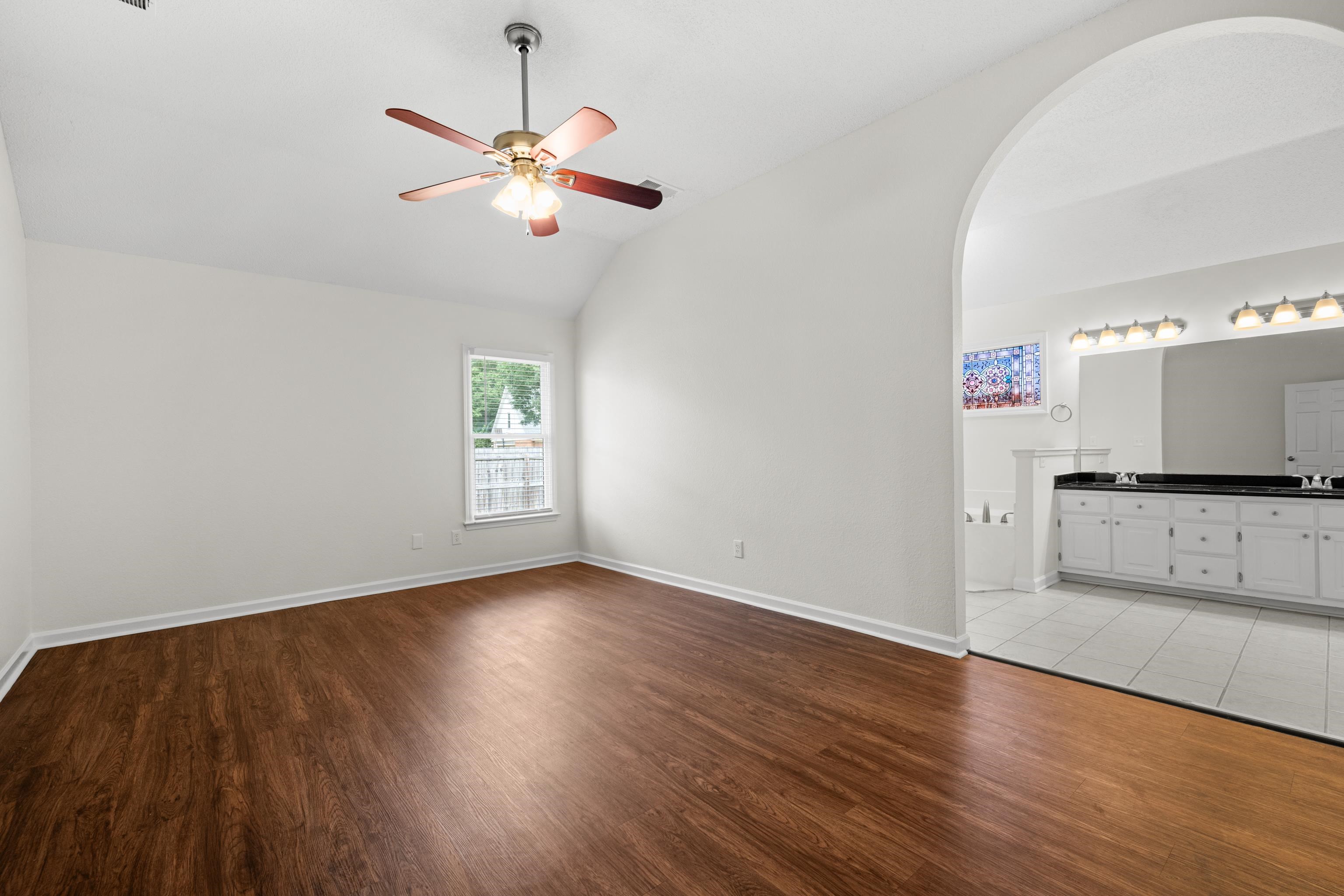 8016 Cale Falls Lane Bartlett, TN 38002 - Photo 18 of 37 an empty room with wooden floor a ceiling fan and windows
