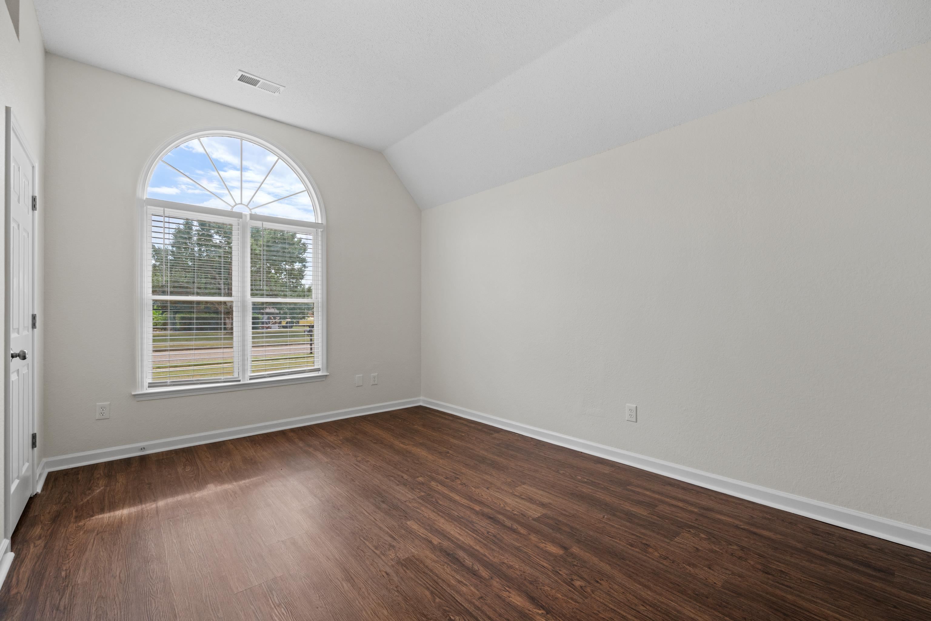 8016 Cale Falls Lane Bartlett, TN 38002 - Photo 22 of 37 an empty room with wooden floor chandelier and windows