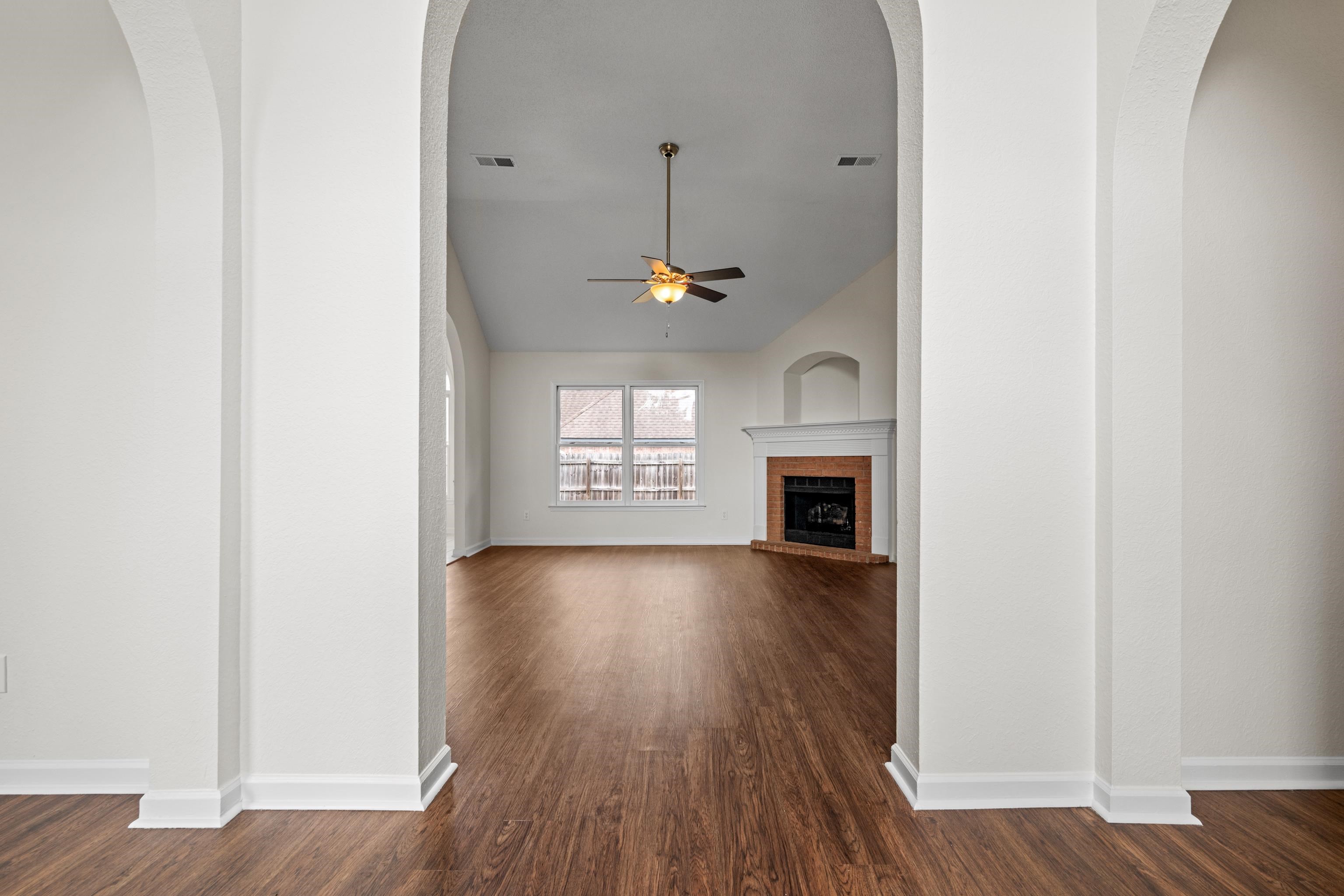 8016 Cale Falls Lane Bartlett, TN 38002 - Photo 4 of 37 an empty room with wooden floor fireplace and windows