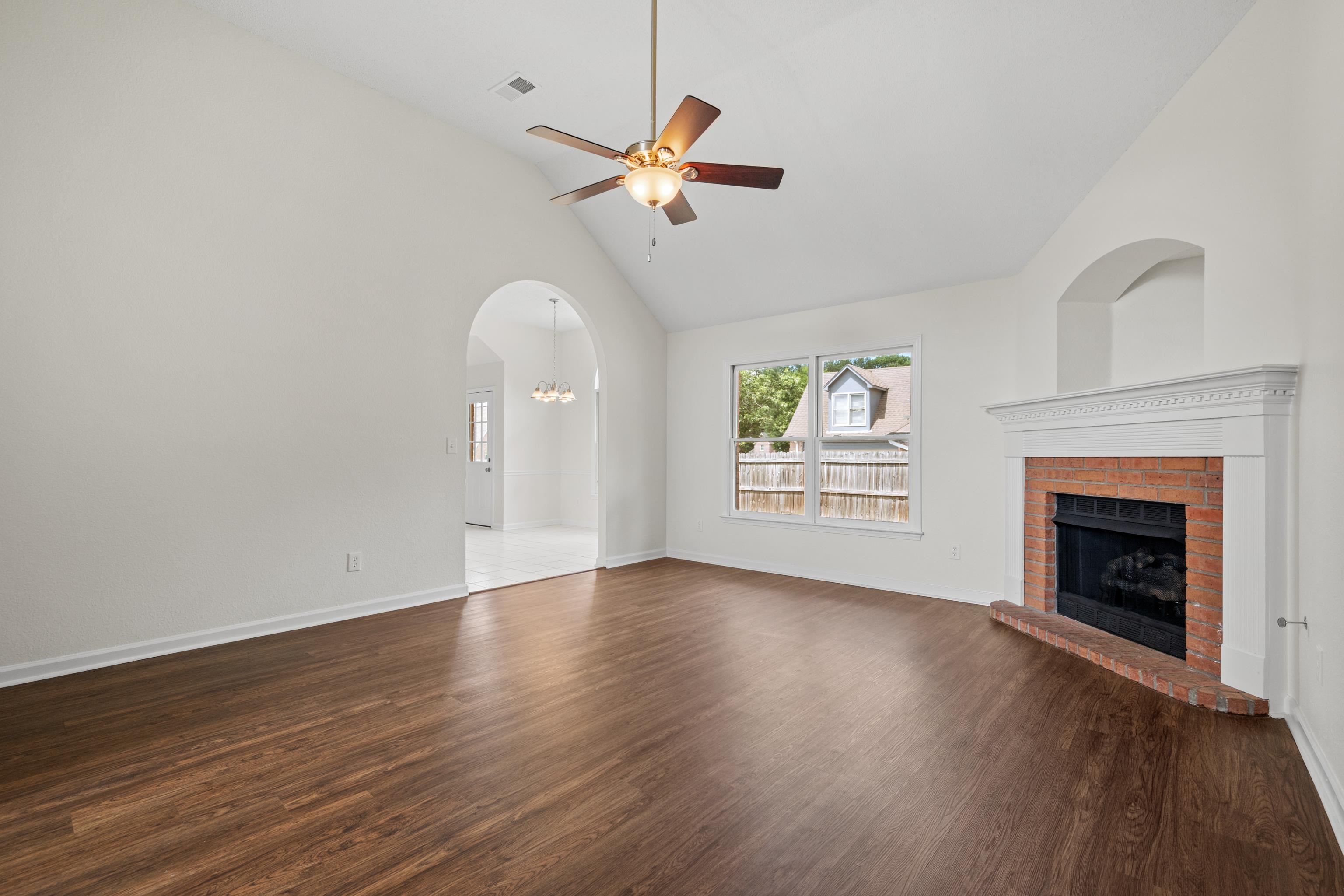 8016 Cale Falls Lane Bartlett, TN 38002 - Photo 5 of 37 a view of an empty room with wooden floor fireplace and a window