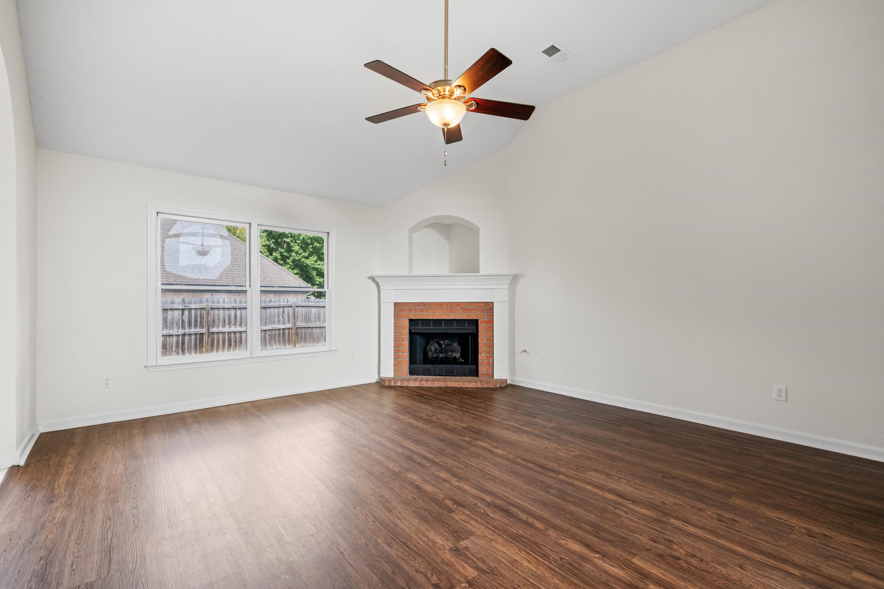 8016 Cale Falls Lane Bartlett, TN 38002 - Photo 6 of 37 a view of an empty room with wooden floor and a fireplace