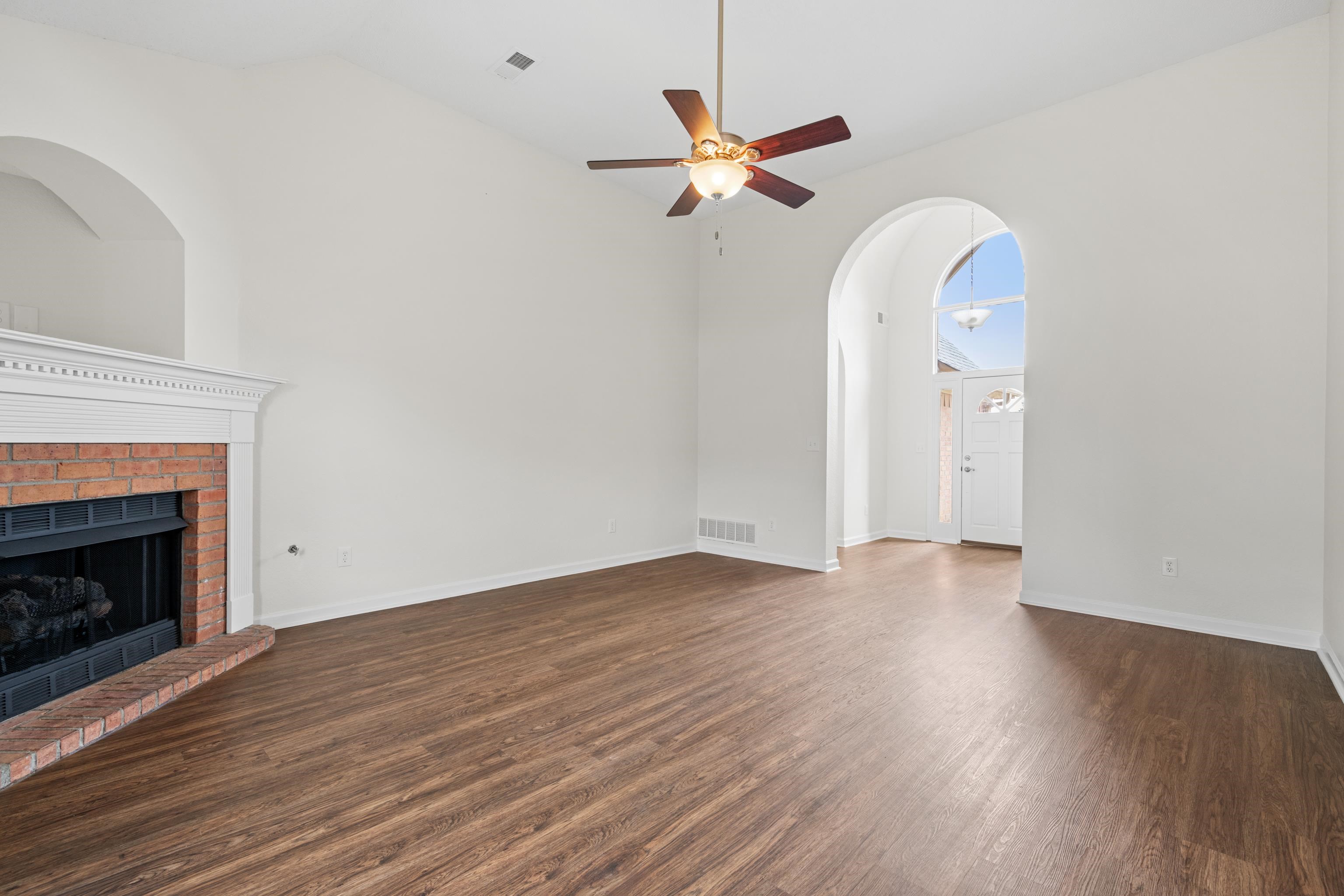 8016 Cale Falls Lane Bartlett, TN 38002 - Photo 7 of 37 an empty room with wooden floor a fireplace
