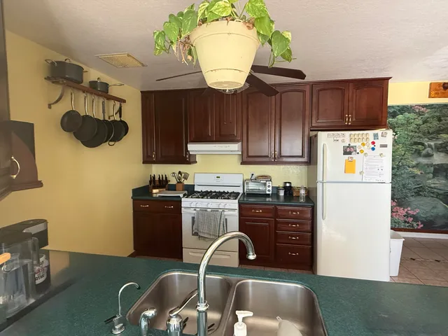 a kitchen with a sink and a stove with wooden floors