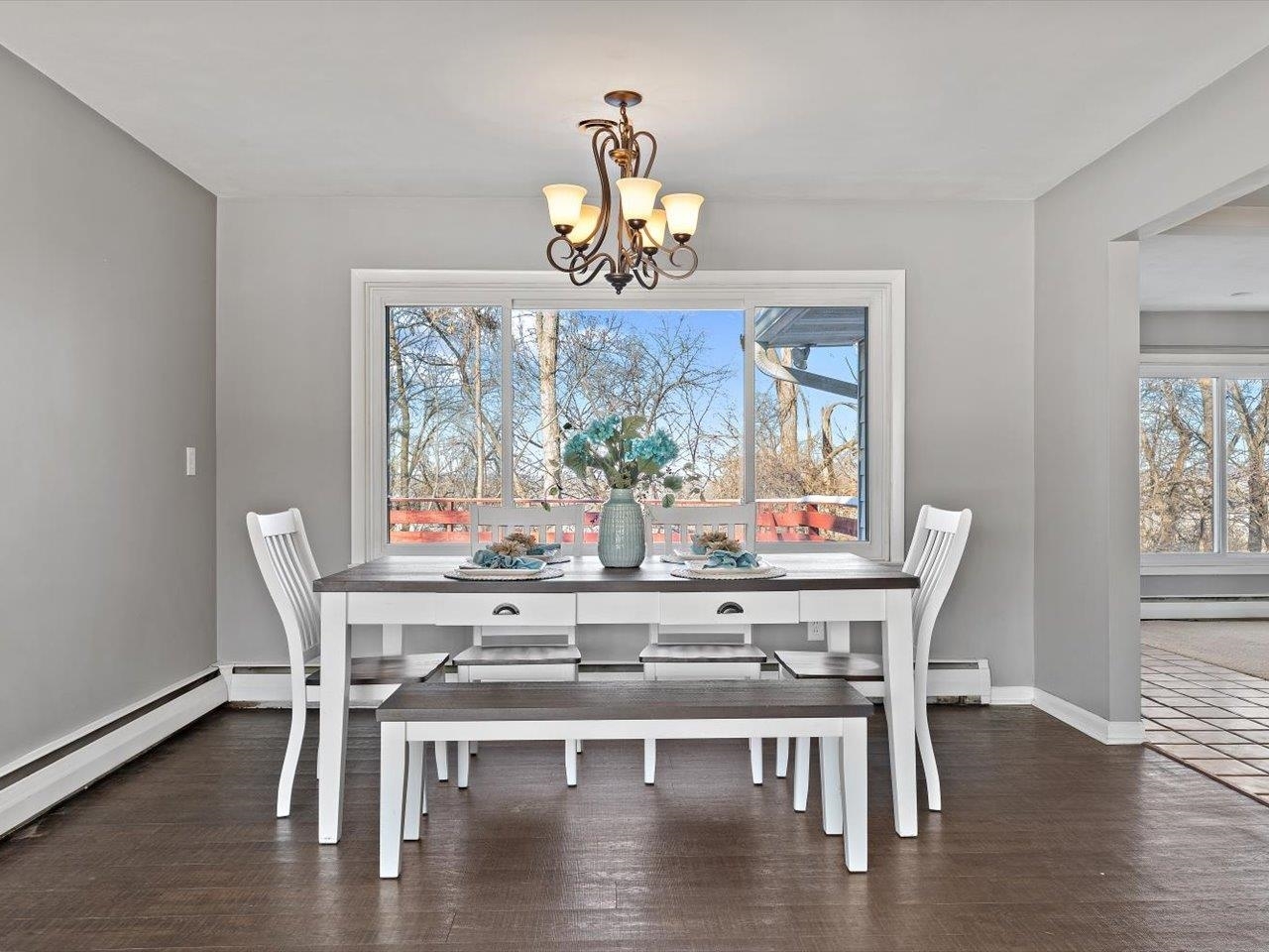 8210 Ridgewood Road Rock Island, IL 61201 - Photo 15 of 60 a dining room with wooden floor a chandelier a wooden table and chairs