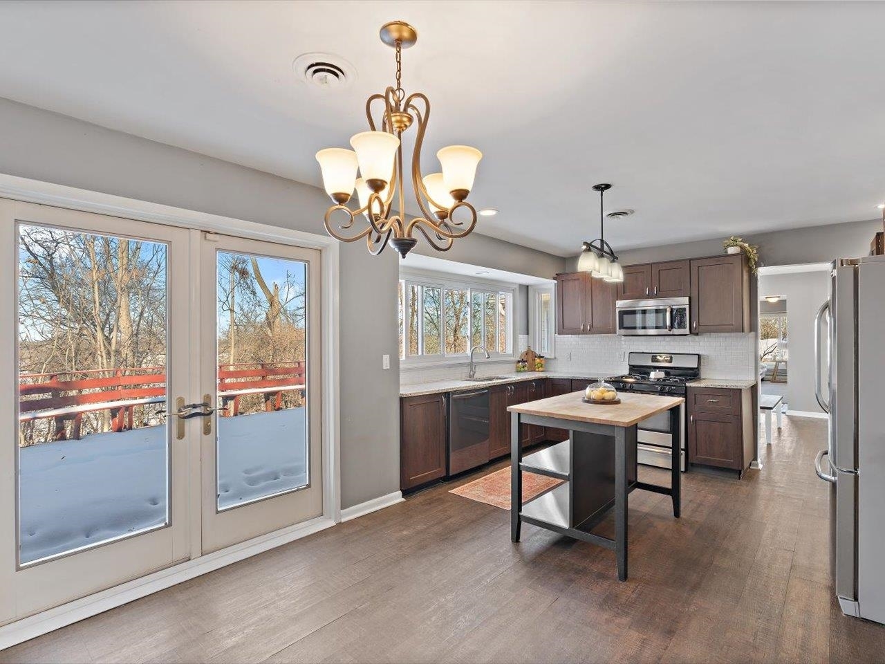 8210 Ridgewood Road Rock Island, IL 61201 - Photo 24 of 60 a view of a dining room with furniture large window a chandelier and wooden floor