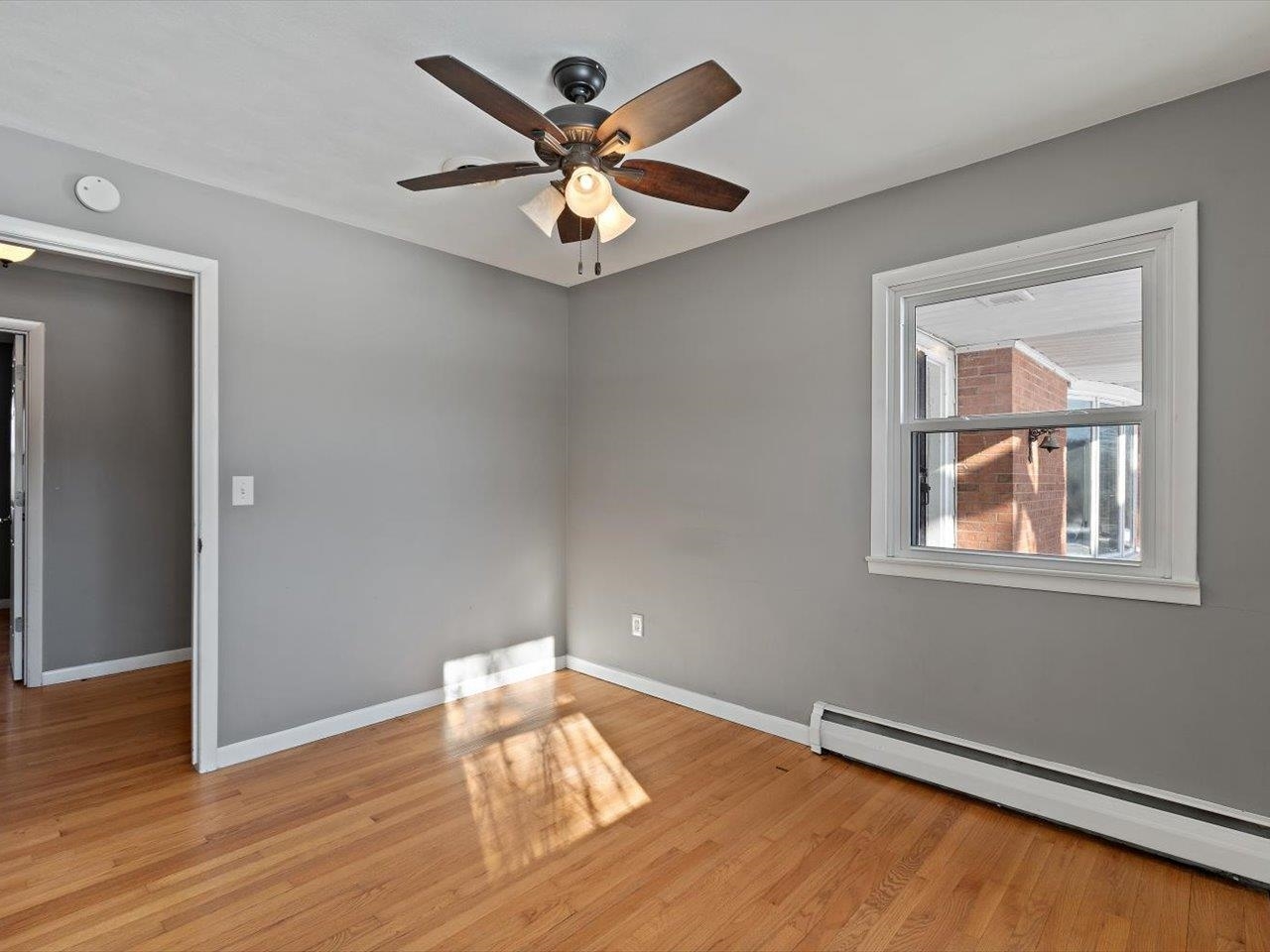 8210 Ridgewood Road Rock Island, IL 61201 - Photo 46 of 60 an empty room with wooden floor chandelier fan and windows