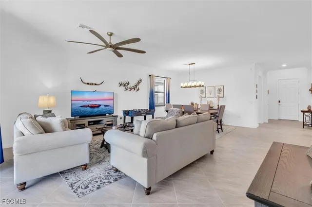 a living room with furniture kitchen view and a chandelier