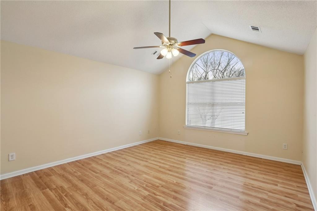 2191 Rockbridge Road Southwest, Unit 1301 Stone Mountain, GA 30087 - Photo 13 of 22 an empty room with wooden floor chandelier fan and windows