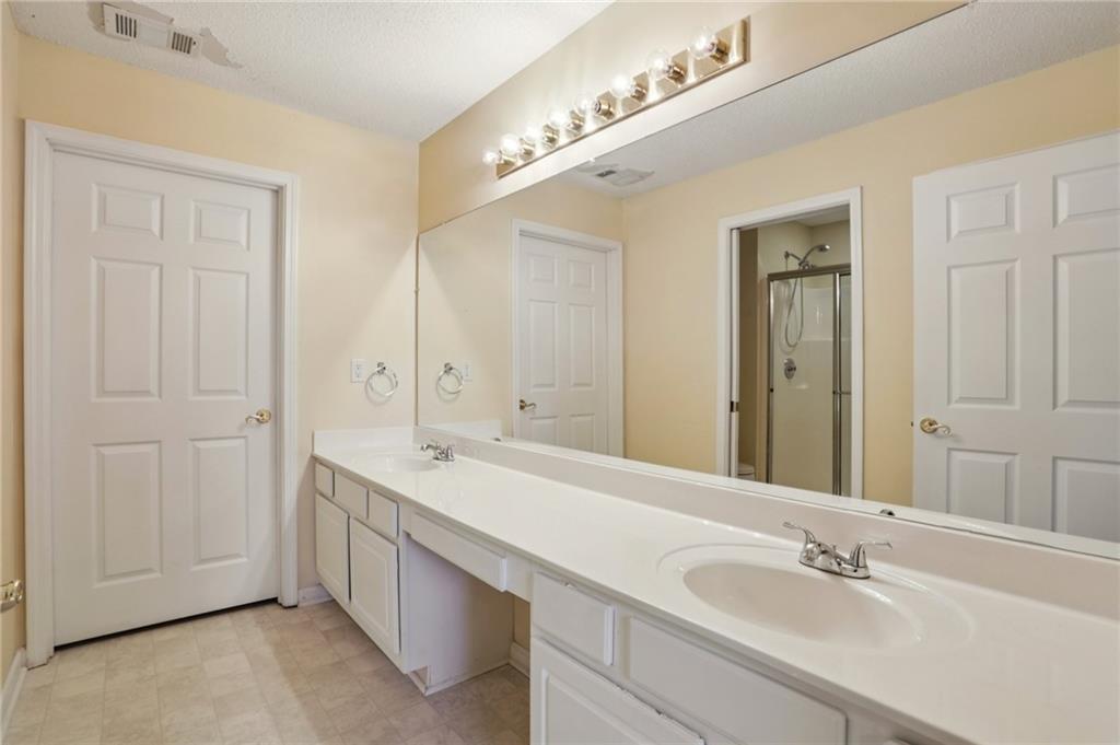 2191 Rockbridge Road Southwest, Unit 1301 Stone Mountain, GA 30087 - Photo 15 of 22 a bathroom with a double vanity sink and a mirror