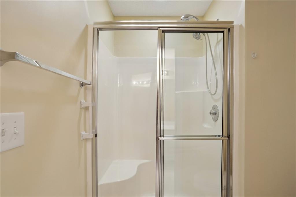2191 Rockbridge Road Southwest, Unit 1301 Stone Mountain, GA 30087 - Photo 16 of 22 a bathroom with a glass shower door