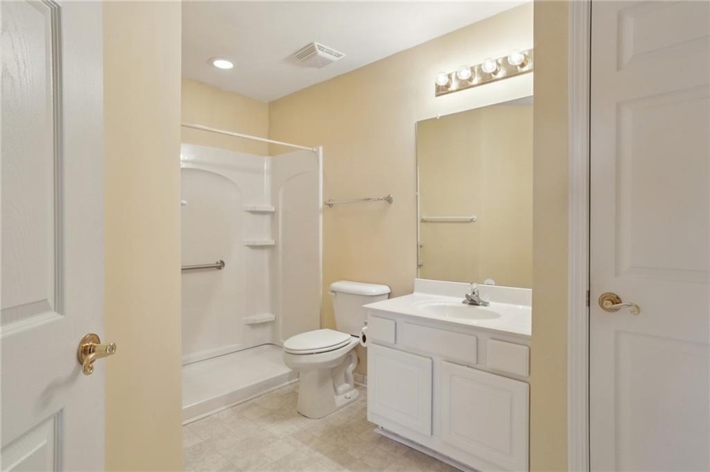 2191 Rockbridge Road Southwest, Unit 1301 Stone Mountain, GA 30087 - Photo 20 of 22 a bathroom with a granite countertop sink a toilet and shower