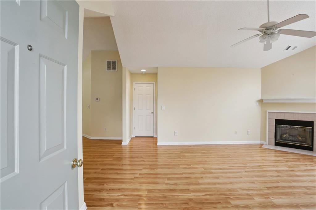 2191 Rockbridge Road Southwest, Unit 1301 Stone Mountain, GA 30087 - Photo 4 of 22 a view of a livingroom with wooden floor and a fireplace