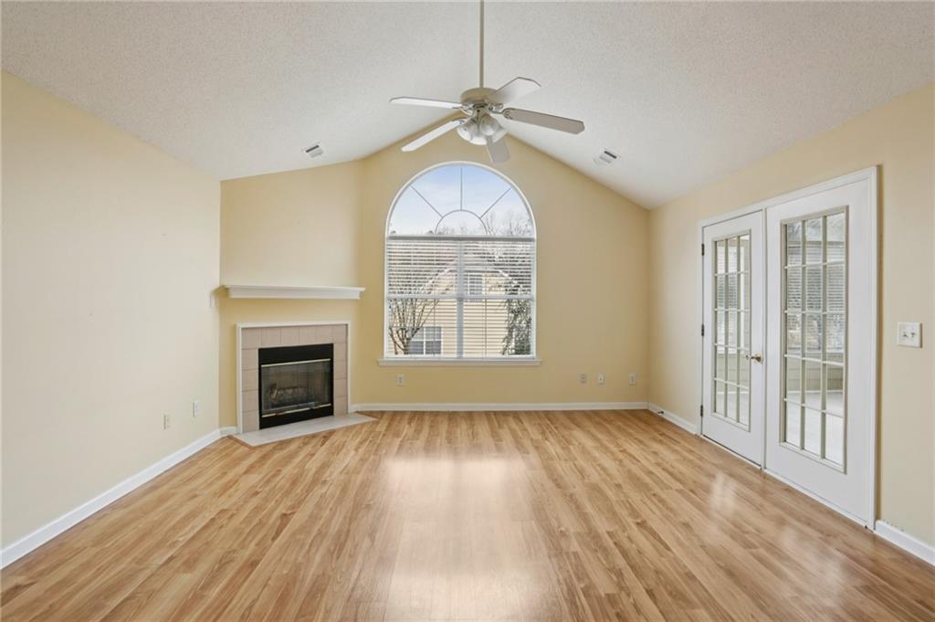 2191 Rockbridge Road Southwest, Unit 1301 Stone Mountain, GA 30087 - Photo 5 of 22 an empty room with wooden floor fireplace and windows