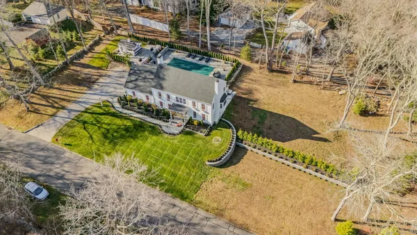 a view of a house with a big yard and large trees