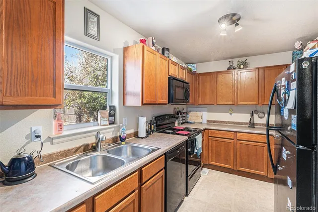 a kitchen with granite countertop a sink stove and cabinets