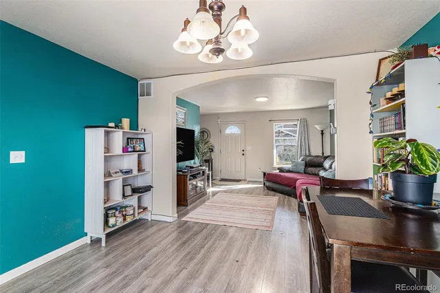 a living room with furniture a flat screen tv and a table