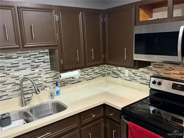 a kitchen with a sink stove and microwave