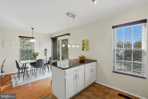 a view of a dining room and livingroom with furniture wooden floor a chandelier