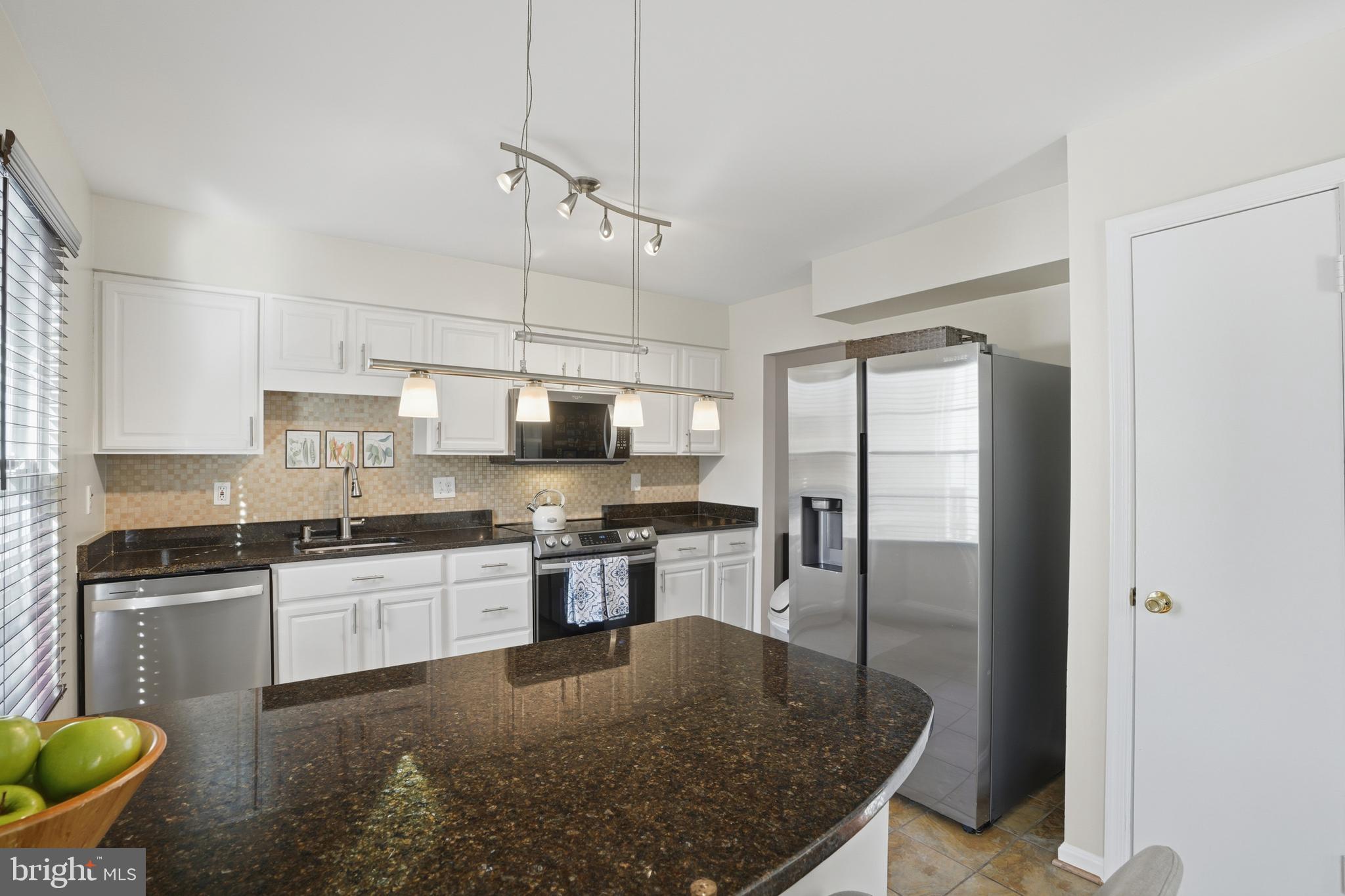 6172 Forest Creek Court Springfield, VA 22152 - Photo 20 of 42 a kitchen with stainless steel appliances granite countertop a sink a stove and a refrigerator