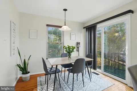 a dining room with furniture potted plants and wooden floor