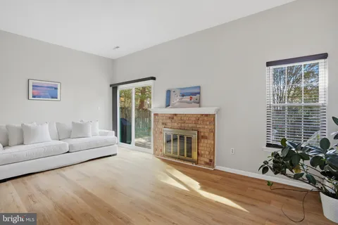 a living room with furniture a fireplace and a potted plant
