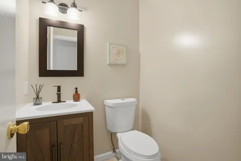 a bathroom with a toilet sink vanity and mirror