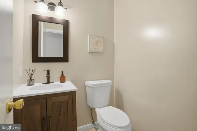 a bathroom with a toilet sink vanity and mirror