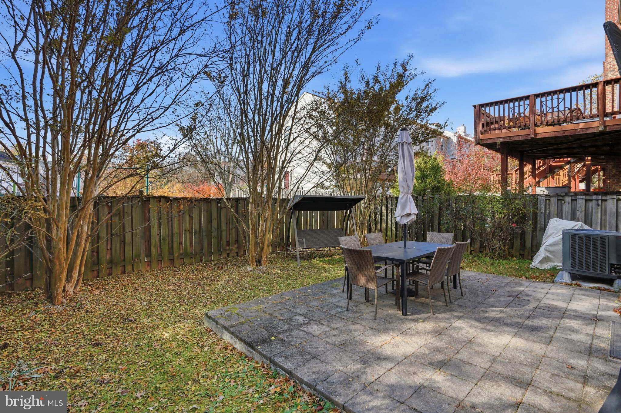 6172 Forest Creek Court Springfield, VA 22152 - Photo 42 of 42 a view of a patio with table and chairs under an umbrella with barbeque grill and wooden fence