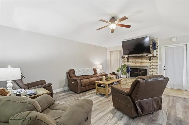 a living room with furniture a flat screen tv and a fireplace