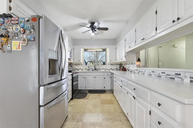 a kitchen with cabinets stainless steel appliances and a window