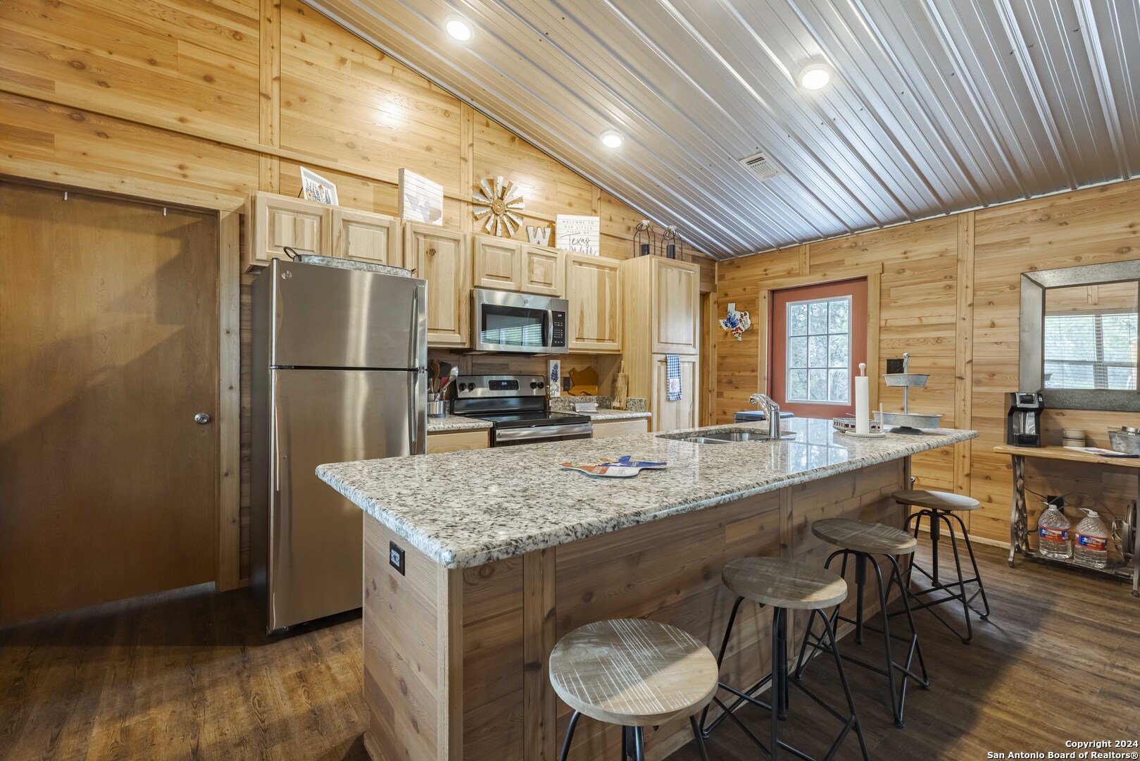 106 Homilius Road Comfort, TX 78013 - Photo 16 of 45 a kitchen with stainless steel appliances granite countertop a sink a stove a refrigerator cabinets and chairs