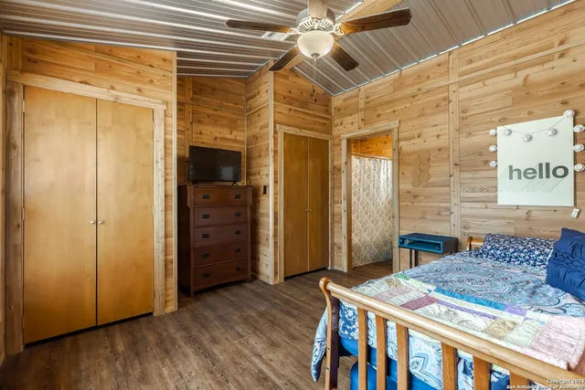 a spacious bedroom with a bed and a flat screen tv