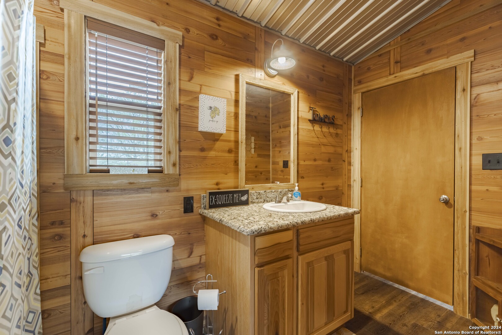 106 Homilius Road Comfort, TX 78013 - Photo 23 of 45 a bathroom with a granite countertop toilet a sink and a mirror
