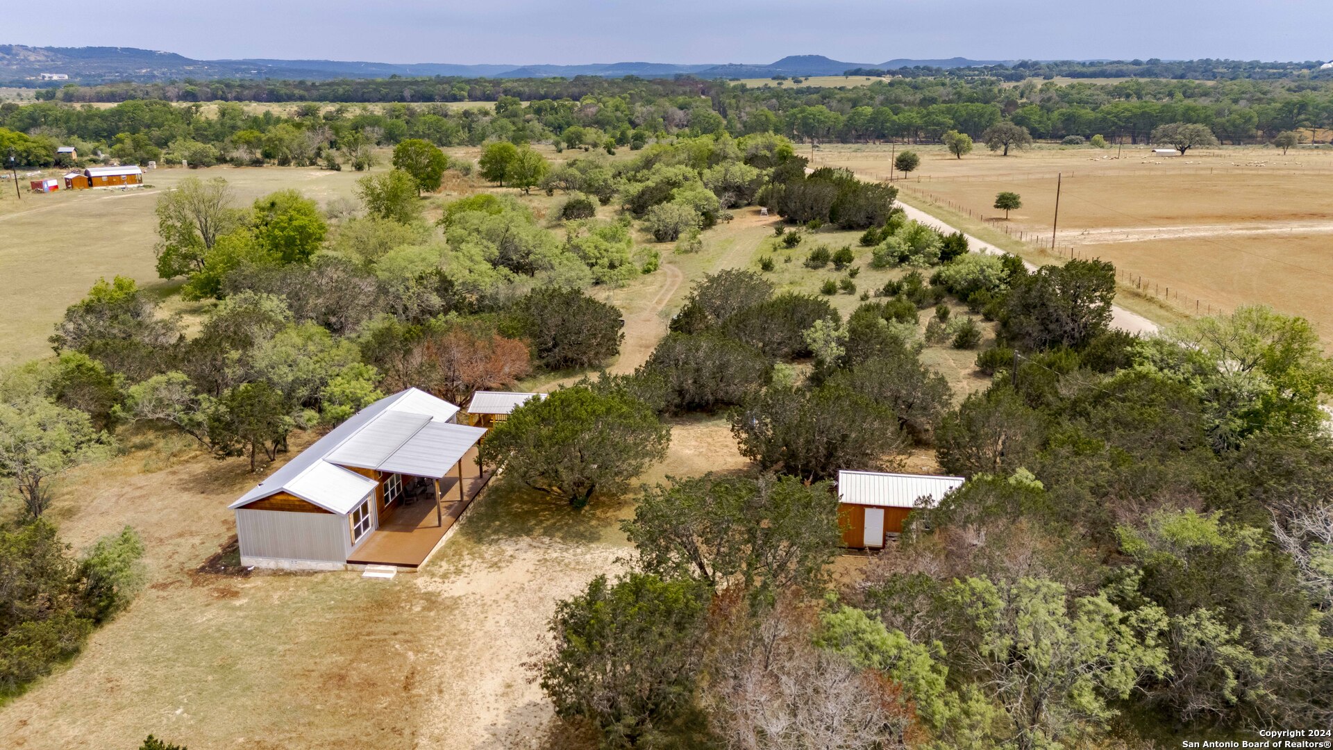 106 Homilius Road Comfort, TX 78013 - Photo 3 of 45 an aerial view of a house with outdoor space and lake view