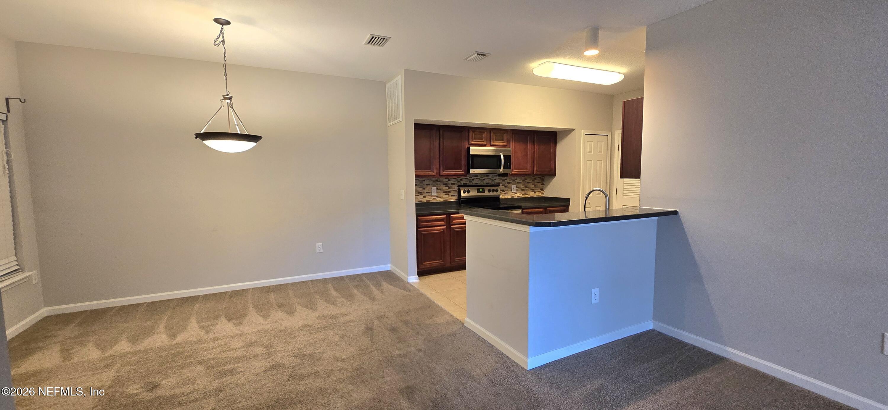 8226 Green Parrot Road, Unit 206 Jacksonville, FL 32256 - Photo 13 of 20 a kitchen with stainless steel appliances granite countertop a stove a sink and a refrigerator