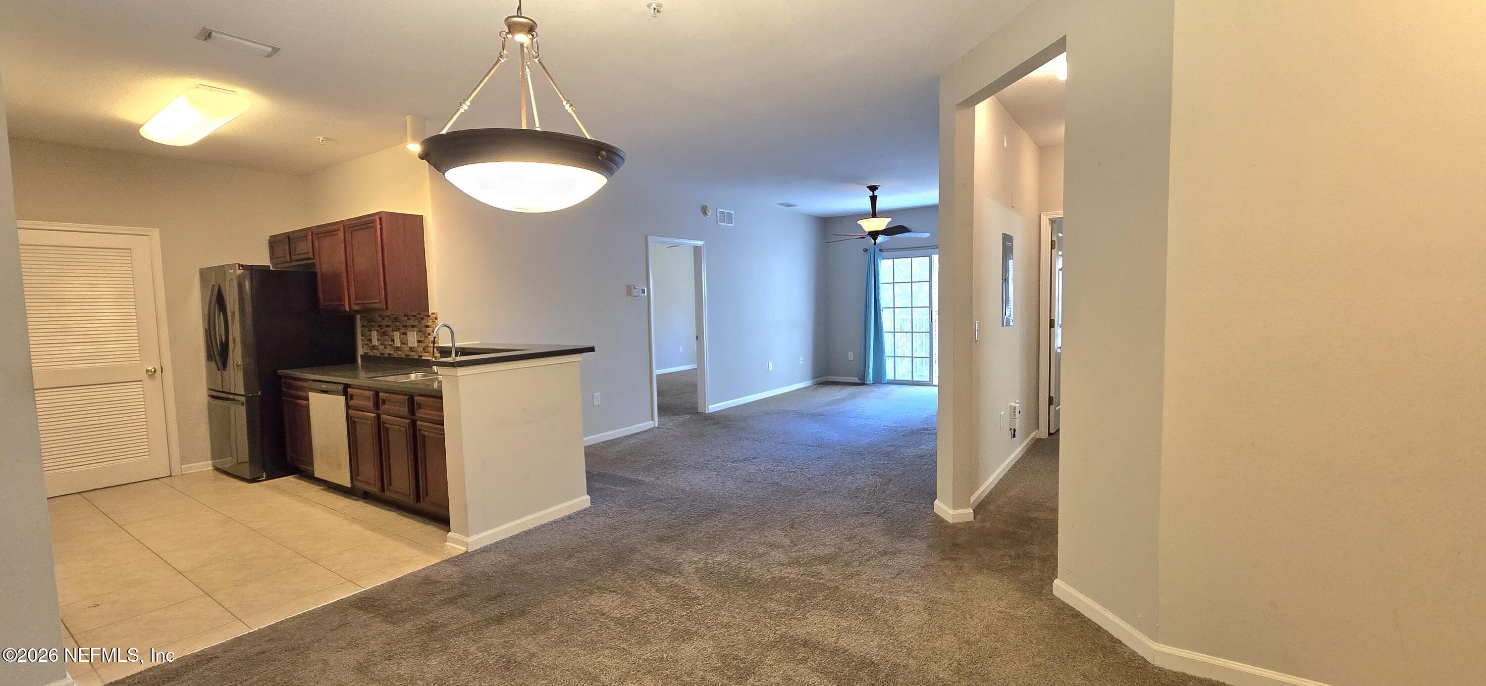 8226 Green Parrot Road, Unit 206 Jacksonville, FL 32256 - Photo 15 of 20 a kitchen with stainless steel appliances granite countertop a refrigerator a stove and a sink