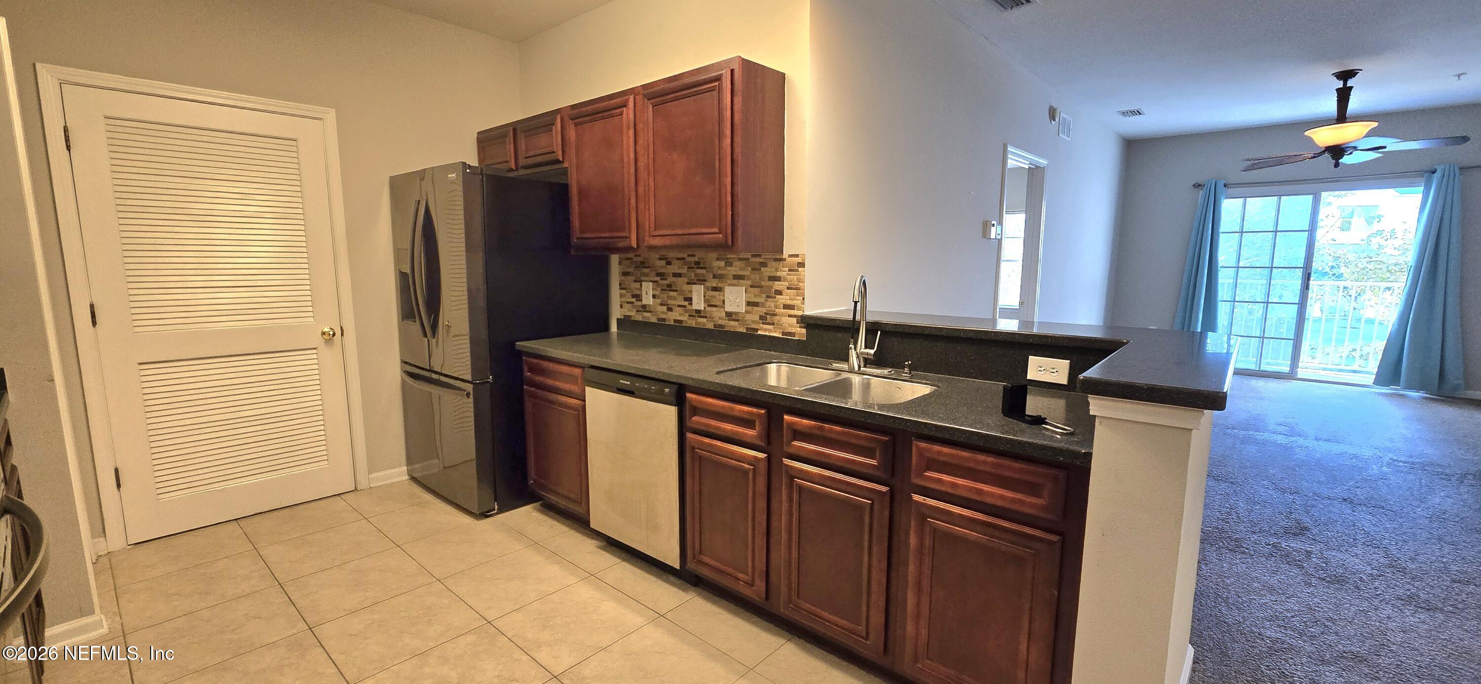 8226 Green Parrot Road, Unit 206 Jacksonville, FL 32256 - Photo 16 of 20 a kitchen with stainless steel appliances granite countertop a sink stove and refrigerator