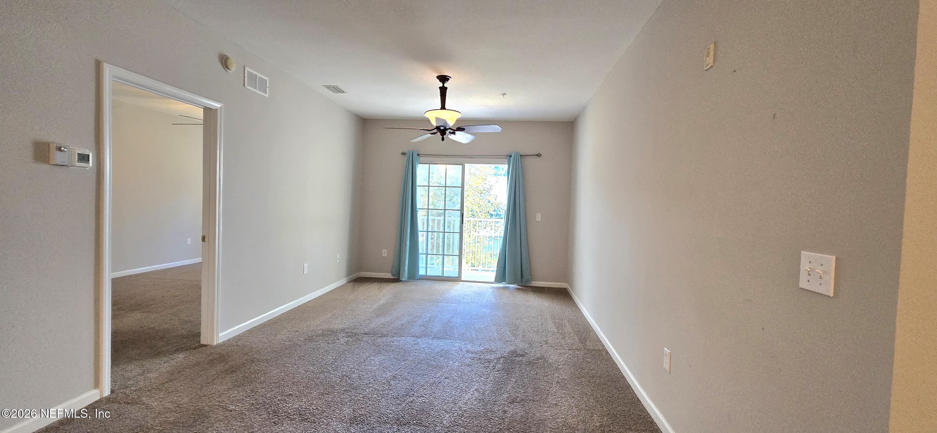 8226 Green Parrot Road, Unit 206 Jacksonville, FL 32256 - Photo 8 of 20 a view of a room with a chandelier fan and windows