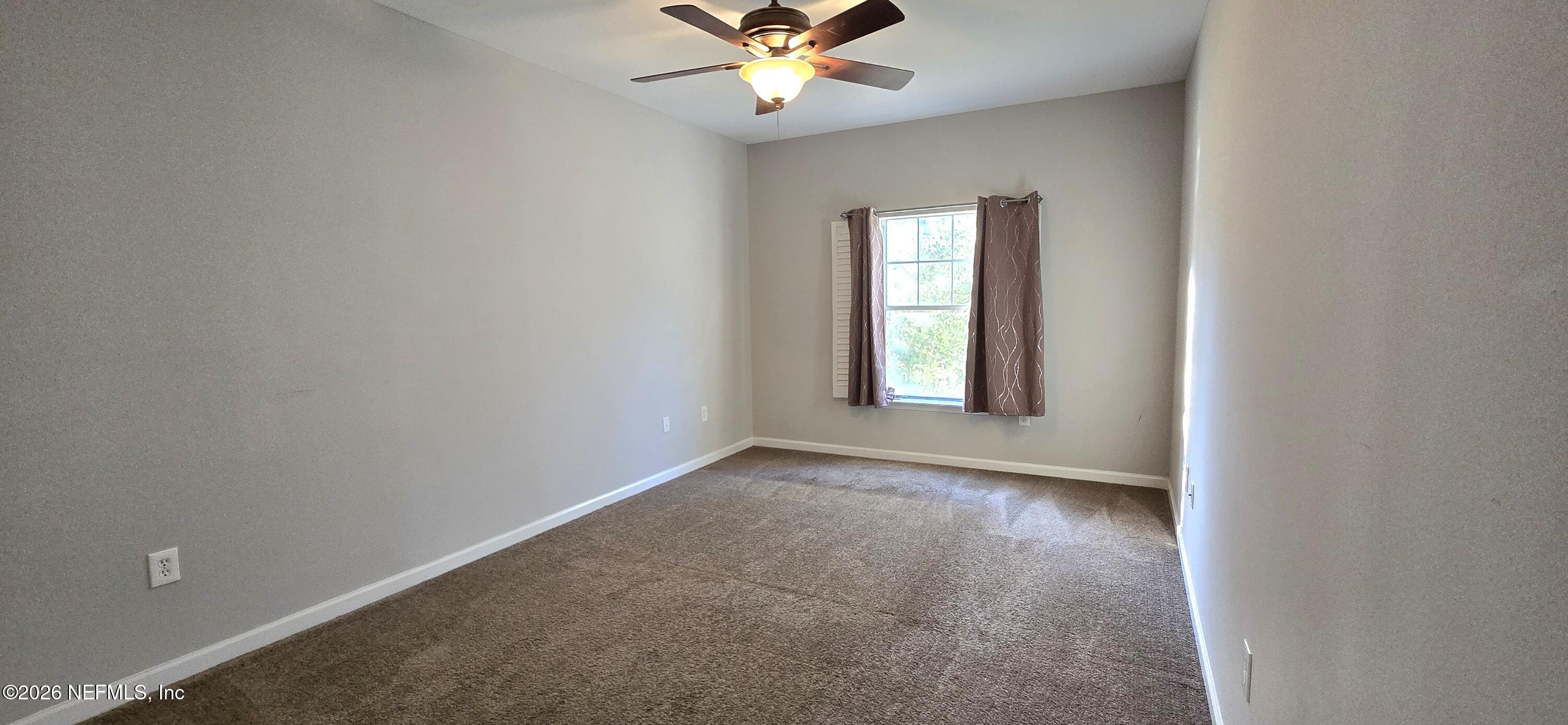 8226 Green Parrot Road, Unit 206 Jacksonville, FL 32256 - Photo 9 of 20 an empty room with windows and fan