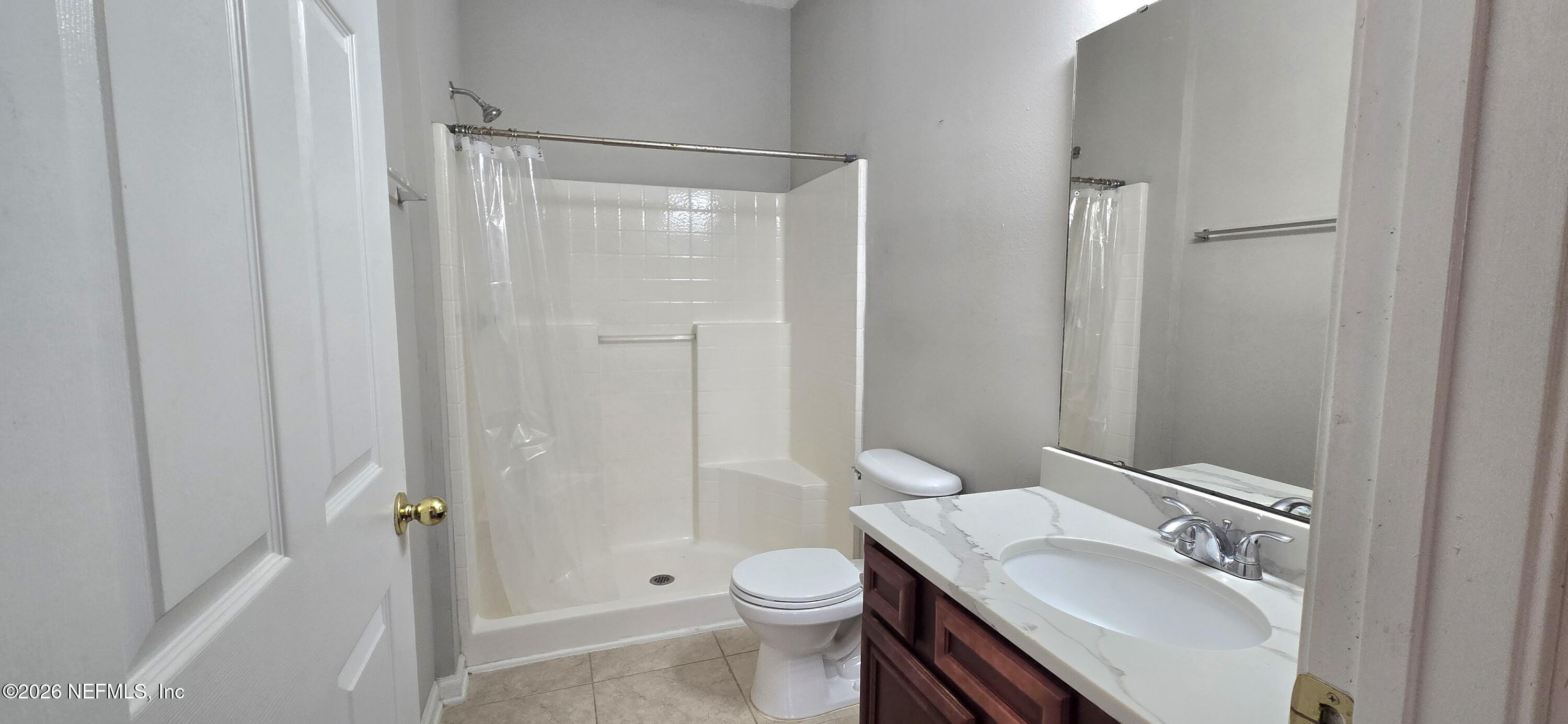 8226 Green Parrot Road, Unit 206 Jacksonville, FL 32256 - Photo 10 of 20 a bathroom with a granite countertop sink toilet and shower