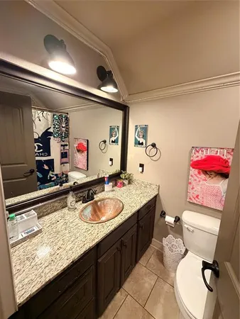 a bathroom with a granite countertop toilet sink and mirror