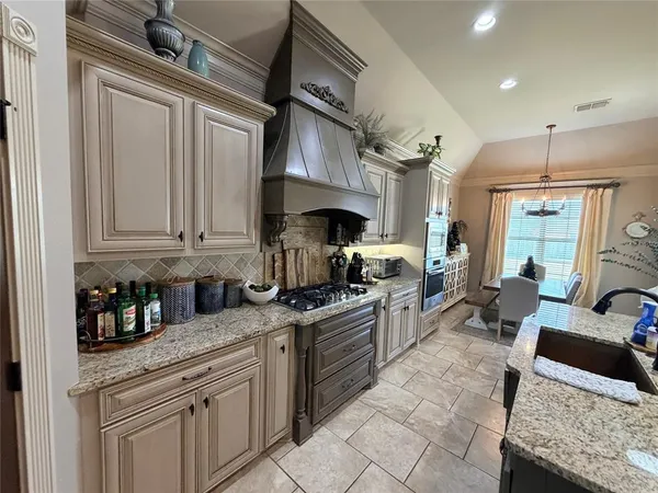 a kitchen with granite countertop a sink stainless steel appliances and cabinets