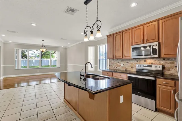 a kitchen with kitchen island granite countertop a sink stainless steel appliances and cabinets