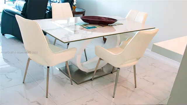 a living room with chairs and white table