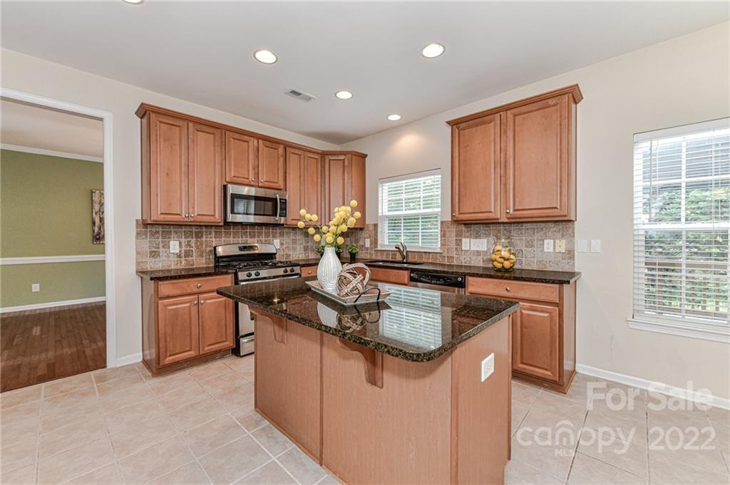 7179 Meyer Road Fort Mill, SC 29715 - Photo 17 of 47 a kitchen with kitchen island granite countertop a stove sink microwave and refrigerator