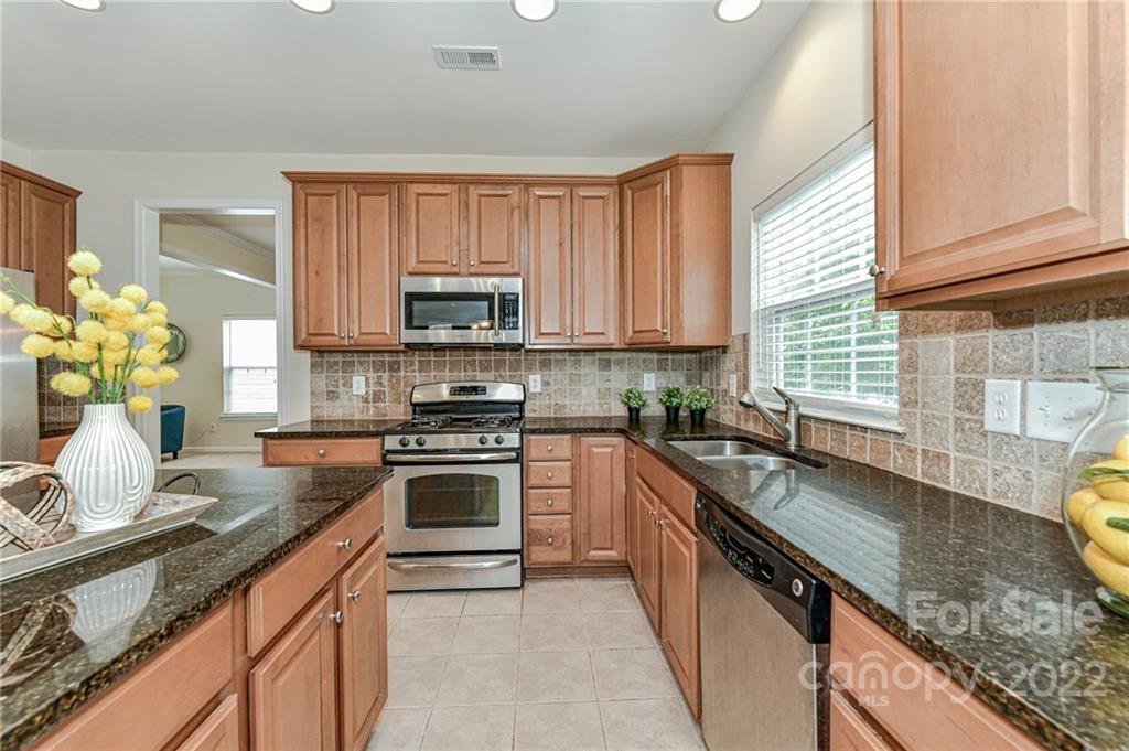 7179 Meyer Road Fort Mill, SC 29715 - Photo 20 of 47 a kitchen with kitchen island granite countertop a sink cabinets stainless steel appliances and a window