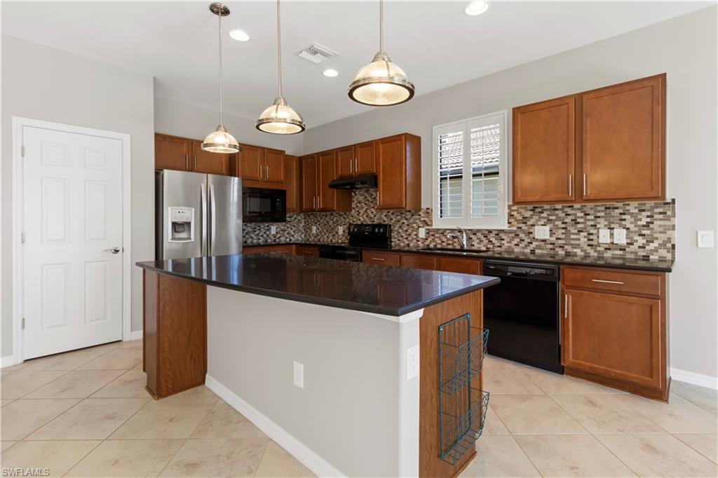 6068 Triumph Lane Ave Maria, FL 34142 - Photo 13 of 27 a kitchen with stainless steel appliances granite countertop a sink a stove a refrigerator a center island a stove and a refrigerator