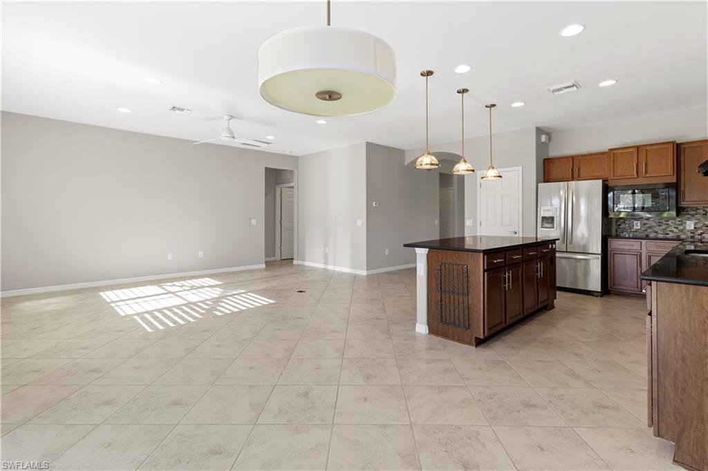 6068 Triumph Lane Ave Maria, FL 34142 - Photo 25 of 27 a large kitchen with stainless steel appliances granite countertop a granite counter tops and a view of living room
