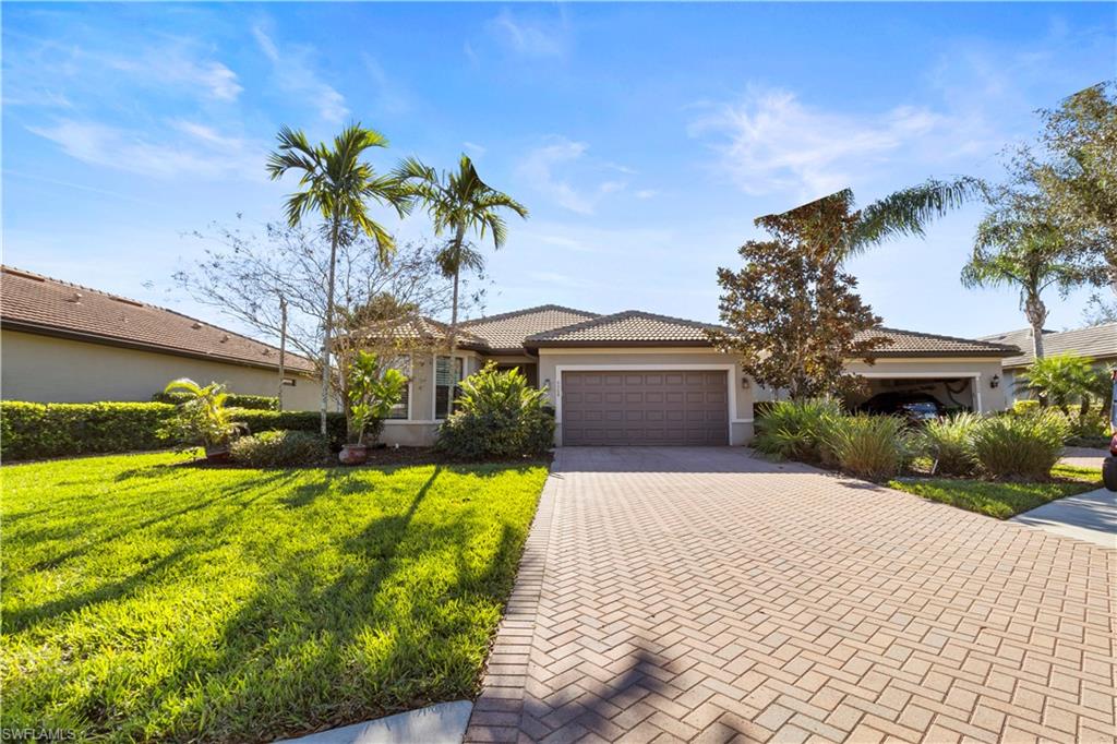 6068 Triumph Lane Ave Maria, FL 34142 - Photo 2 of 27 a front view of a house with a yard and palm trees
